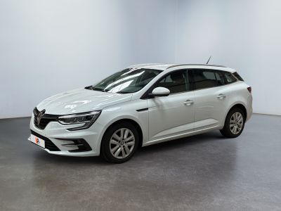 Une voiture blanche est garée dans une pièce blanche au sol noir.