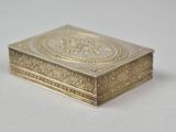 an image of a gold box sitting on top of a white table