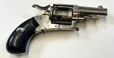 un revolver argenté avec une poignée noire sur une surface blanche