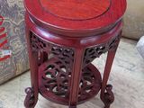 une petite table au plateau rouge posée par terre