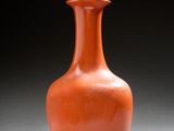 un vase orange posé sur une table