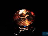 gros plan d'un diamant orange sur une surface noire