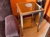 a glass table with a bowl on it in the corner of a living room