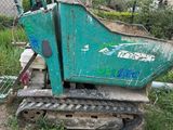 une machine verte qui est à l'arrêt dans la boue