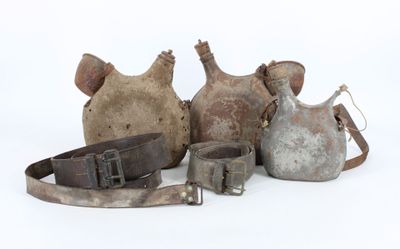 several pieces of old metal items are sitting on a white surface