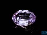 a close up of a purple diamond on a black surface