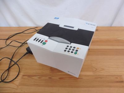 un boîtier blanc posé sur une table, avec une télécommande dessus