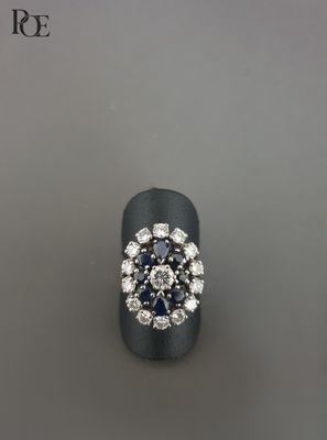 une photo d'une bague sertie d'un diamant et d'un saphir posée sur une table