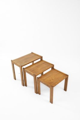 trois tables en bois empilées les unes sur les autres sur une surface blanche