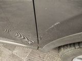 a close up of a car ' s front door with a person ' s foot on the ground