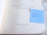 un livre ouvert, sur lequel est collé un autocollant, posé sur un lit