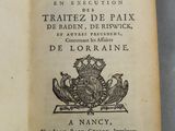 un livre ouvert sur lequel figurent un blason et une couronne