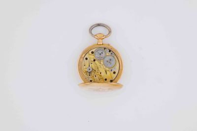 a close up of a gold pocket watch on a white surface