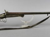 an old rifle with a wooden barrel on a stand