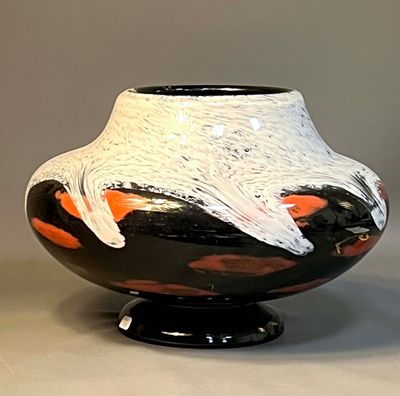 a black and white vase with orange designs on it