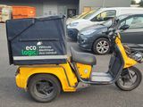 a yellow scooter with a black box on the back of it