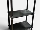 une étagère noire avec un plateau métallique sur fond blanc