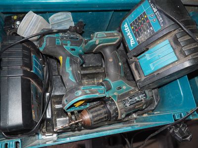 une perceuse sans fil et deux batteries dans une boîte bleue