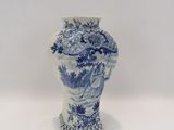 un vase bleu et blanc posé sur une surface blanche