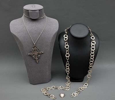 deux colliers et un collier posé sur un présentoir pour mannequin
