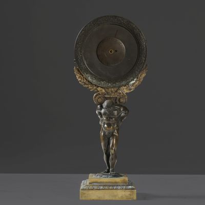 une statue en bronze représentant un homme tenant un bouclier au-dessus de sa tête