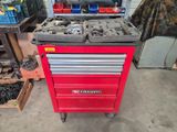 un chariot à outils rouge contenant des outils, dans un garage