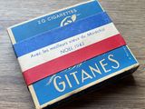 des cigarettes sont posées sur une table en bois, à côté d'un paquet de cigarettes