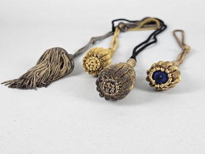 trois bijoux ornés de pompons et de perles sur un fond blanc