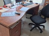 un bureau avec un ordinateur et une chaise devant une fenêtre