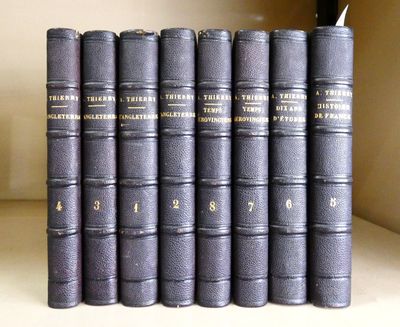 cinq livres sur une étagère, sur lesquels figurent des inscriptions dorées