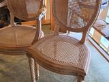 pair of wicker chairs in a living room with a fireplace in the background