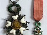deux médailles et un ruban rouge sur un fond blanc