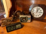 many different clocks on a wooden table in a room