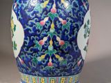 a blue vase with a design of flowers and birds on it