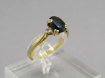 gros plan d'une bague en or avec une pierre noire