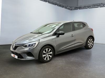 La voiture grise est garée dans une grande pièce aux murs blancs.