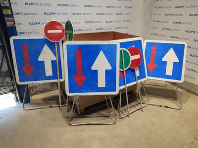 four signs with arrows on them in a room