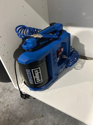 a blue spray gun sitting on a shelf in a room