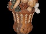 a statue of a vase with fruit and vegetables in it