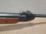 an old rifle with a wooden handle on a table