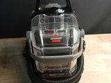 the vacuum is sitting on a wooden table with a black wall in the background