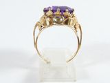 a close up of a gold ring with a purple stone