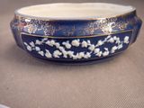 a blue bowl with white flowers on it sitting on a table