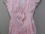 a pink and white checkered dress hanging on a wall