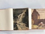 un livre ouvert sur lequel figurent une cascade et une église