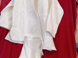 a white robe on a red blanket next to a sign