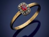 gros plan d'une bague en or avec une pierre rouge