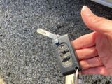 a person holding a car key in front of a car