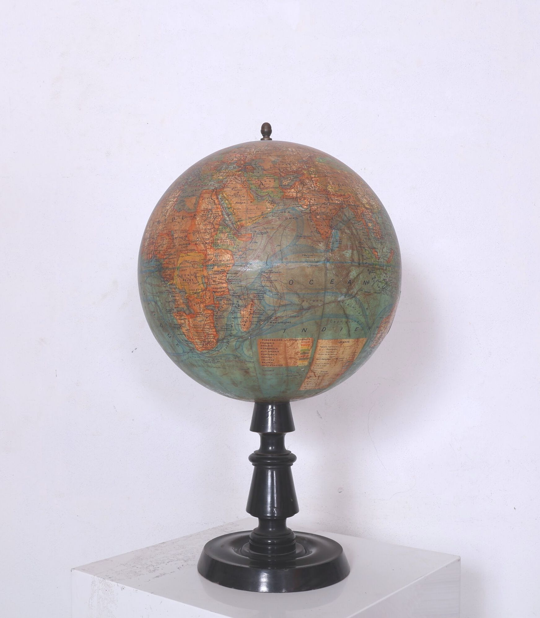 Globe terrestre en carton lithographié, la base en bois noirci. Époque XIXème siècle. H_54 cm, enfoncements et petits...