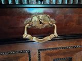 a close up of a brass handle on a wooden cabinet